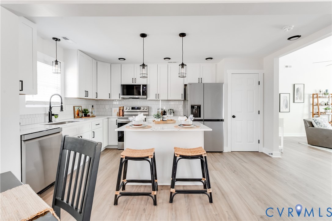 10298 Jamestown Road Ashland, VA 23005 - Photo 20 of 46 a kitchen with stainless steel appliances kitchen island a table chairs sink and cabinets