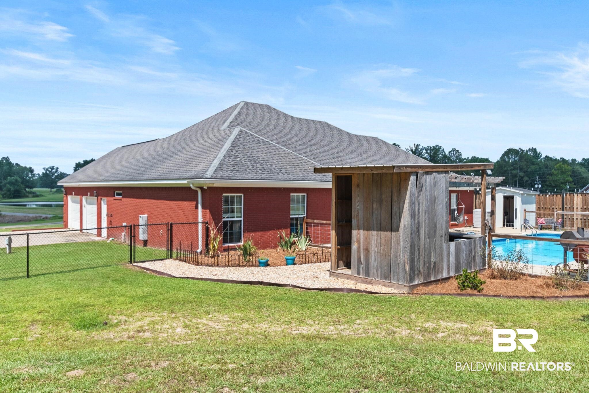 79 Whitetail Run Chatom, AL 36518 - Photo 65 of 82 Fenced backyard featuring a swimming pool, wooden pergola, and a rustic outdoor bar structure