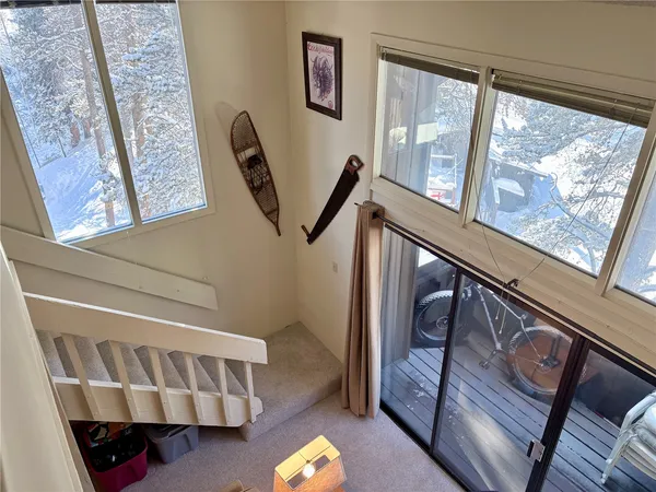 a view of staircase with lots of frames on wall and a window