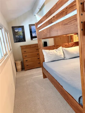 a bedroom with a bed and painting on the wall