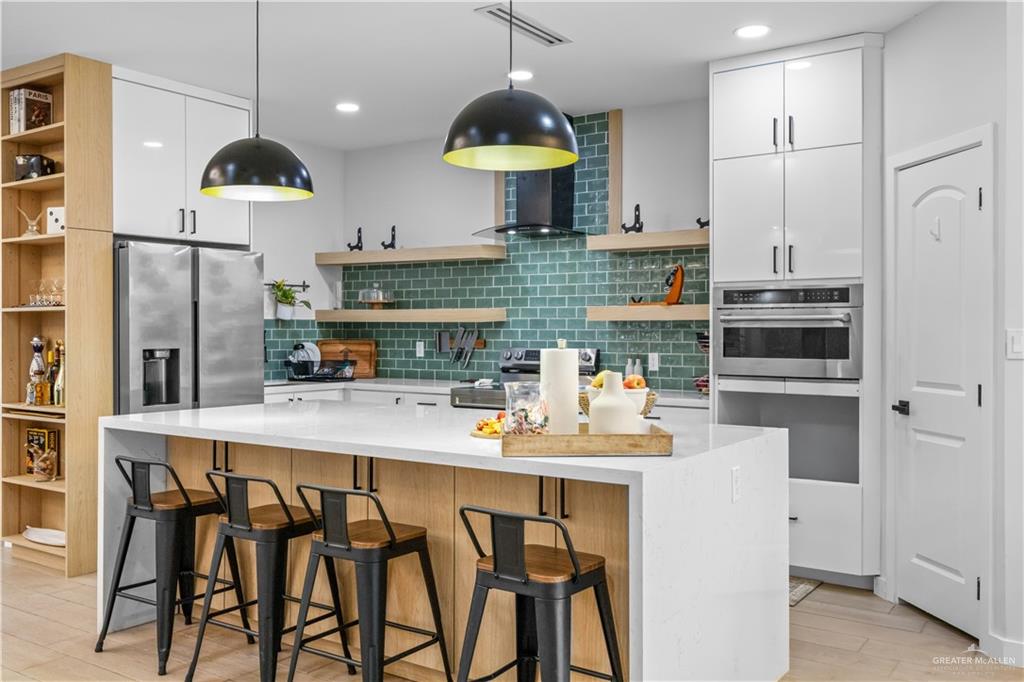 2800 Encke Rd Mission Mission, TX 78574 - Photo 6 of 21 a kitchen with stainless steel appliances a dining table chairs stove and refrigerator