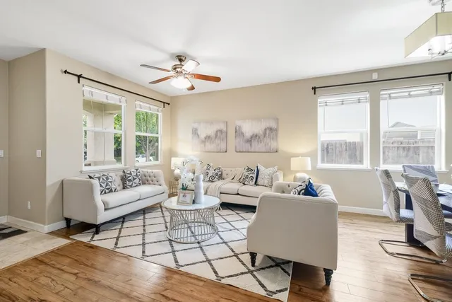 a dining room with wooden floor a chandelier a wooden table and chairs