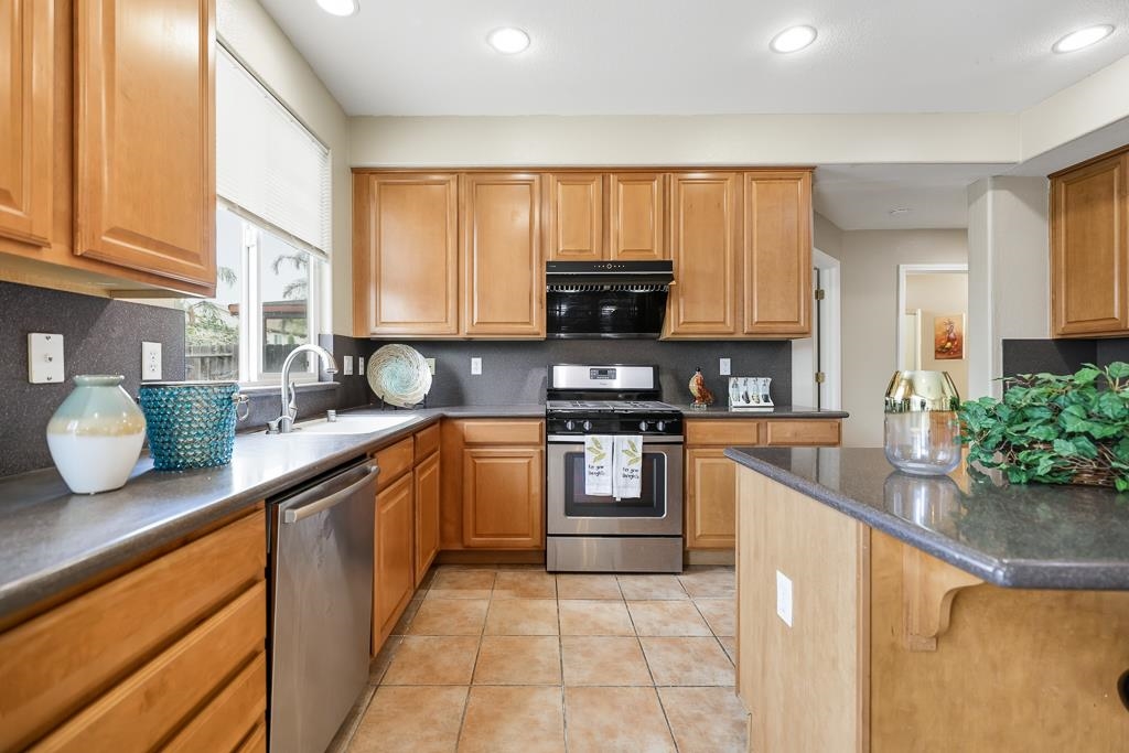 1413 Angus Street Patterson, CA 95363 - Photo 31 of 60 a kitchen with stainless steel appliances granite countertop a sink counter space cabinets and a large window