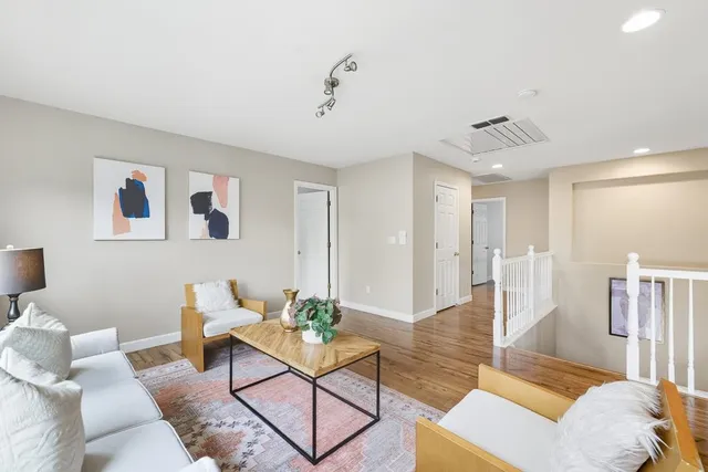 a living room with furniture and wooden floor