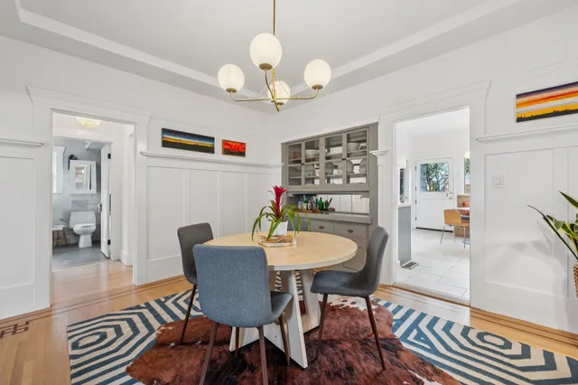 a dining room with furniture a chandelier and wooden floor