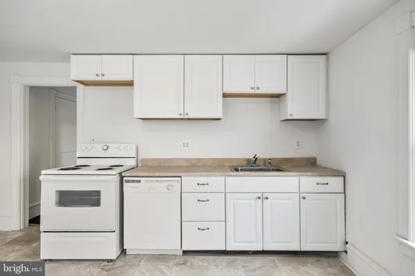 a kitchen with granite countertop white cabinets and white appliances