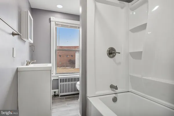 a bathroom with a tub a sink and a window