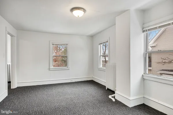 a view of a big room with windows and chandelier fan