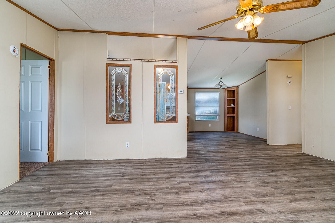 1600 Wheatstraw Road Amarillo, TX 79118 - Photo 4 of 18 a view of an empty room with wooden floor and a kitchen