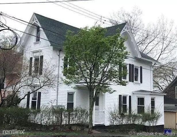 a view of a white house next to a yard