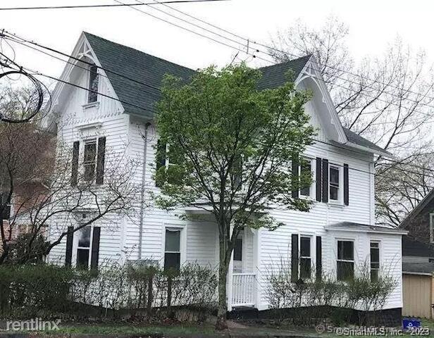 a view of a white house next to a yard