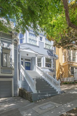 a view of a white house with a large tree