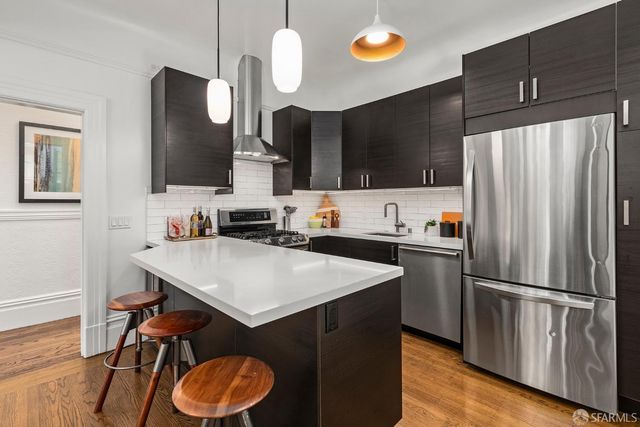 a kitchen with stainless steel appliances a refrigerator and a stove top oven