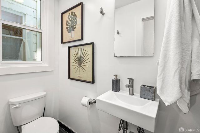 a bathroom with a toilet a sink and a window