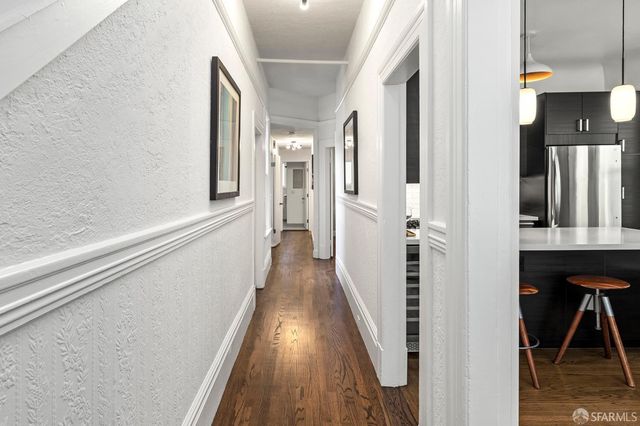 a view of a hallway with wooden floor and staircase