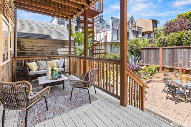a view of balcony with wooden floor outdoor seating and city view