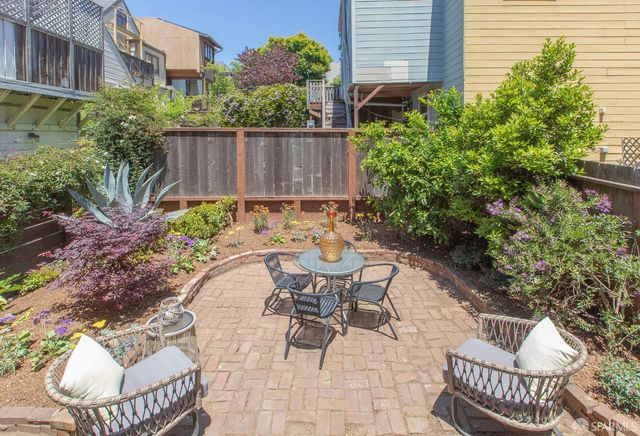 a view of a patio with table and chairs and potted plants