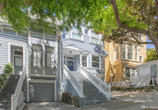 a front view of a house with a tree