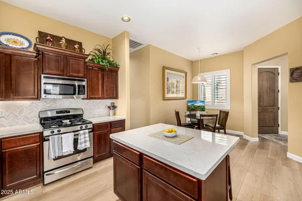 a kitchen with a stove a sink dishwasher and a refrigerator with wooden floor