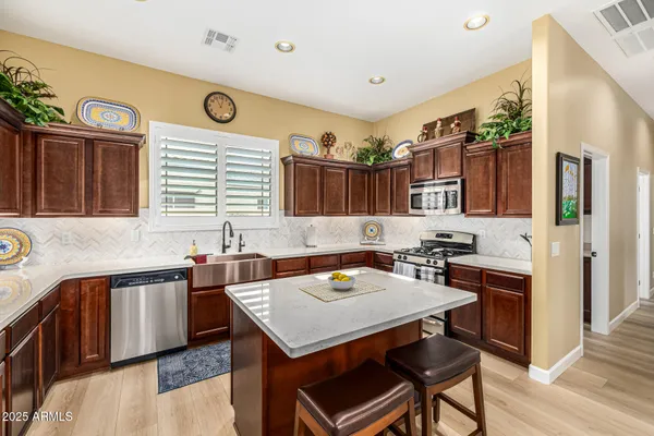 a kitchen with stainless steel appliances granite countertop a refrigerator and a sink