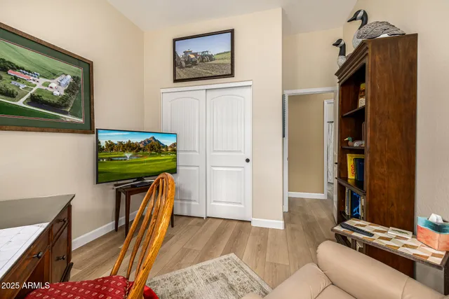 a living room with furniture a bookshelf and a window