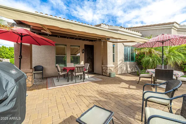 a view of a patio with a table and chairs under an umbrella