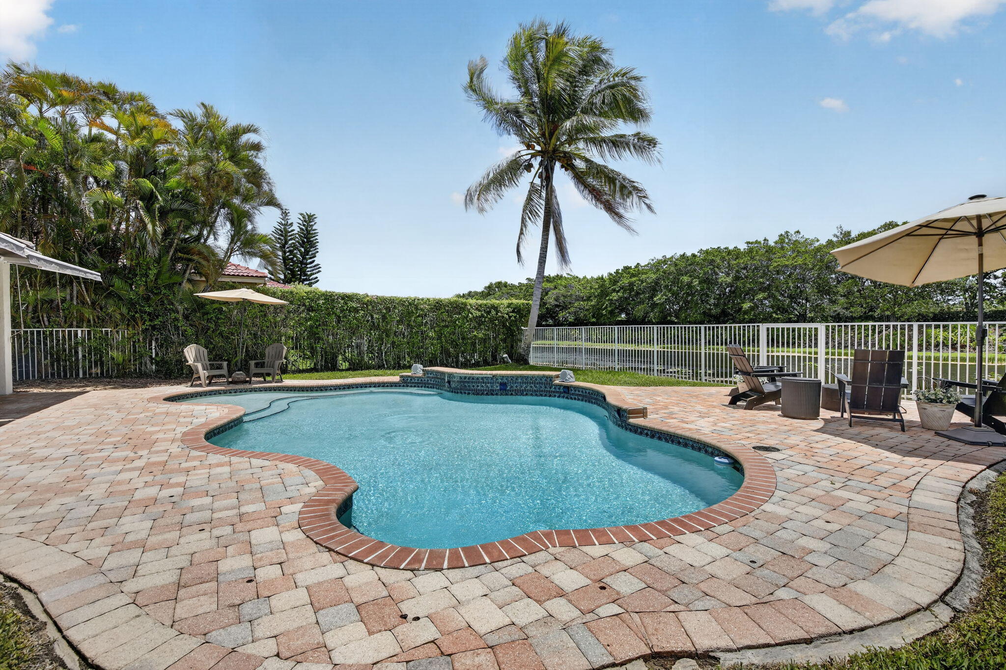 4299 Laurel Ridge Circle Weston, FL 33331 - Photo 76 of 103 a view of a swimming pool with a lounge chair and palm trees