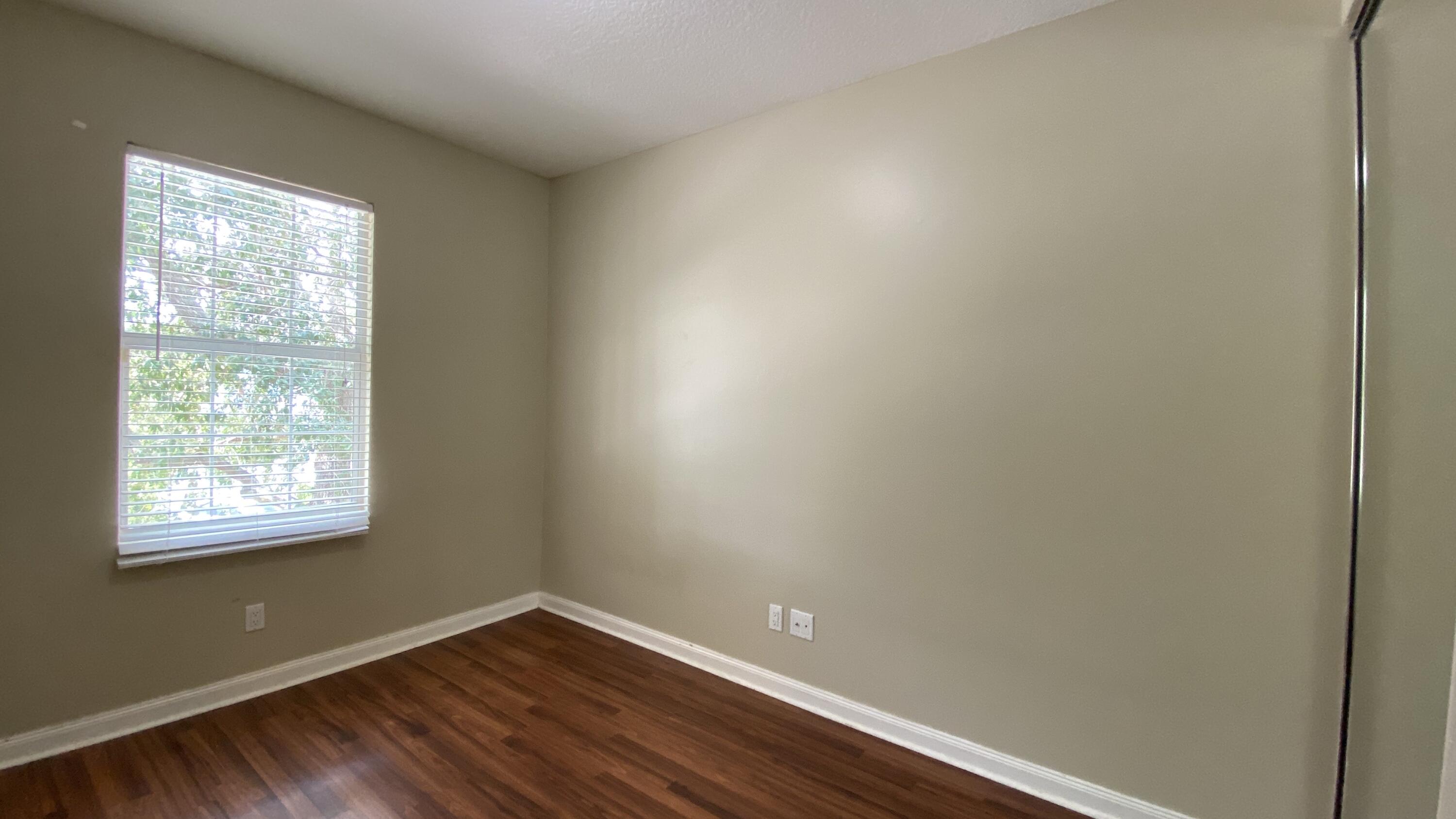 3200 West Community Drive Jupiter, FL 33458 - Photo 11 of 31 an empty room with wooden floor and windows