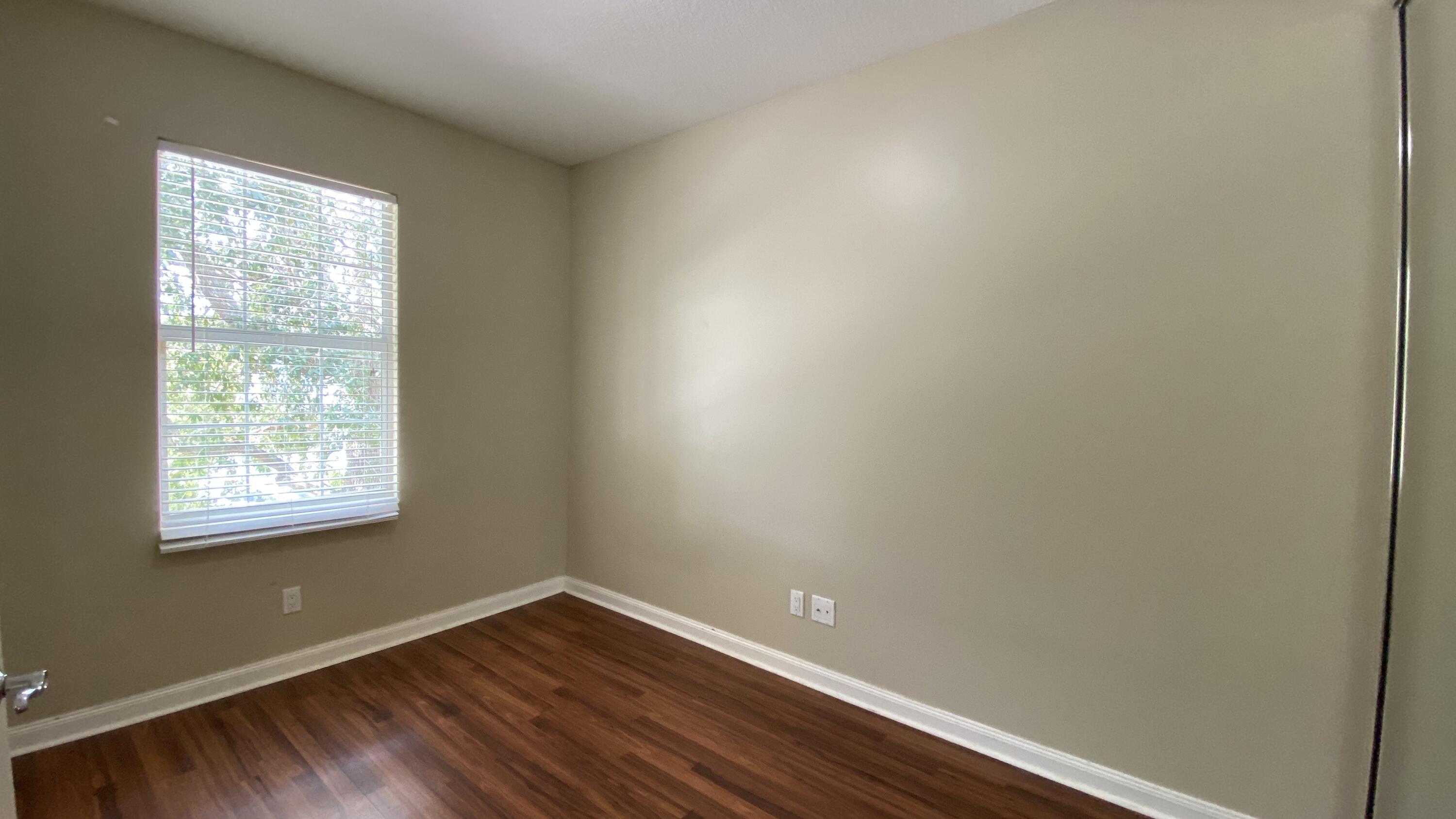 3200 West Community Drive Jupiter, FL 33458 - Photo 12 of 31 an empty room with wooden floor and windows