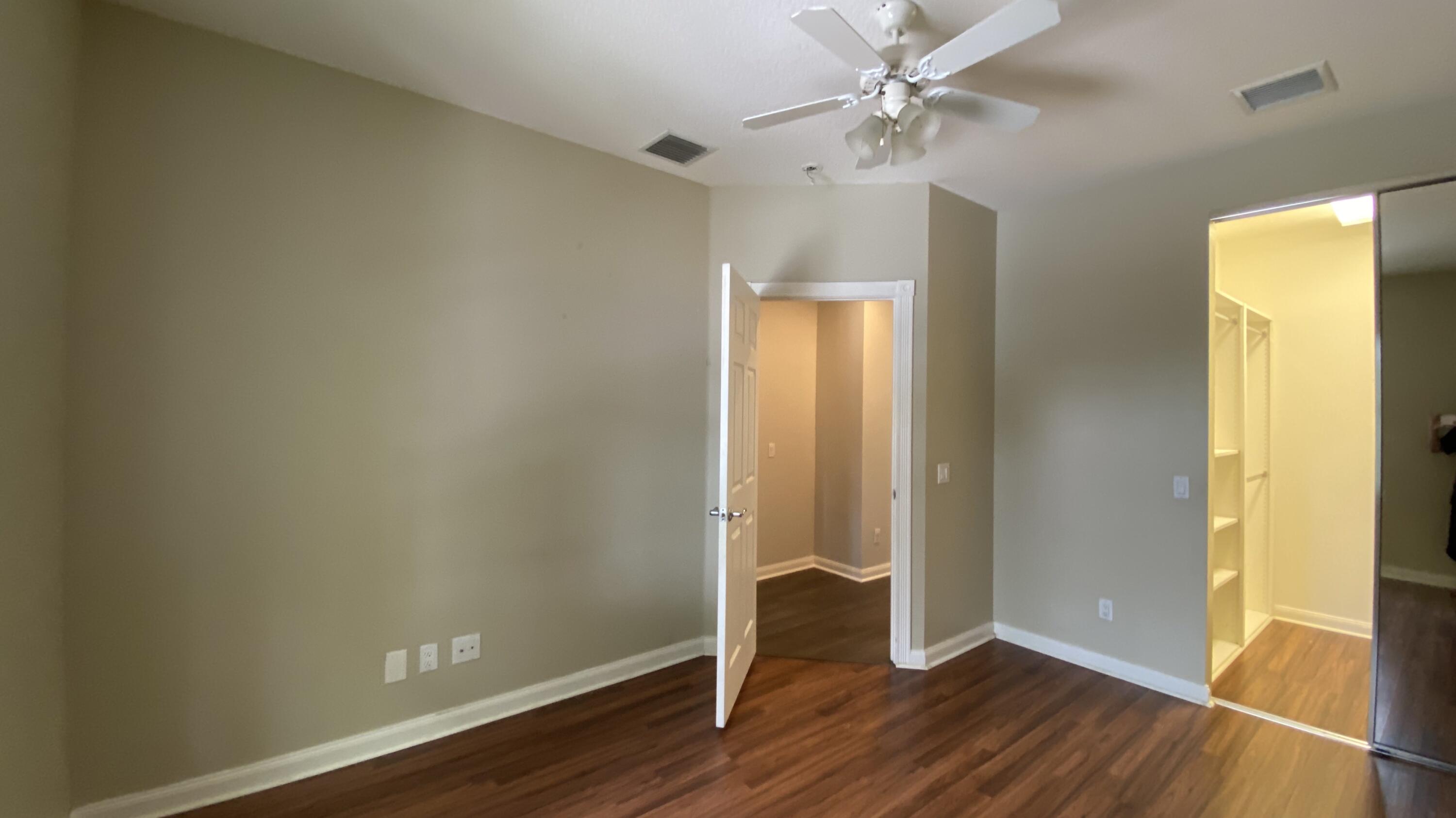 3200 West Community Drive Jupiter, FL 33458 - Photo 13 of 31 an empty room with wooden floor and a ceiling fan