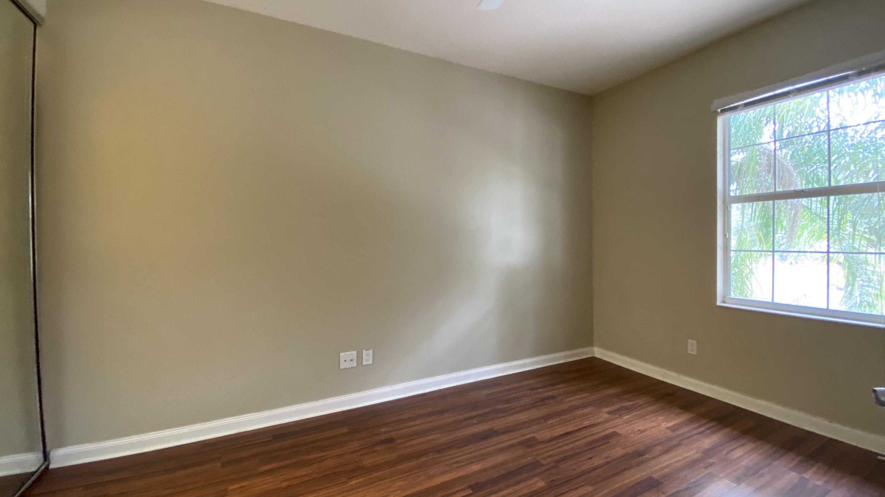 3200 West Community Drive Jupiter, FL 33458 - Photo 14 of 31 a view of an empty room with wooden floor and a window