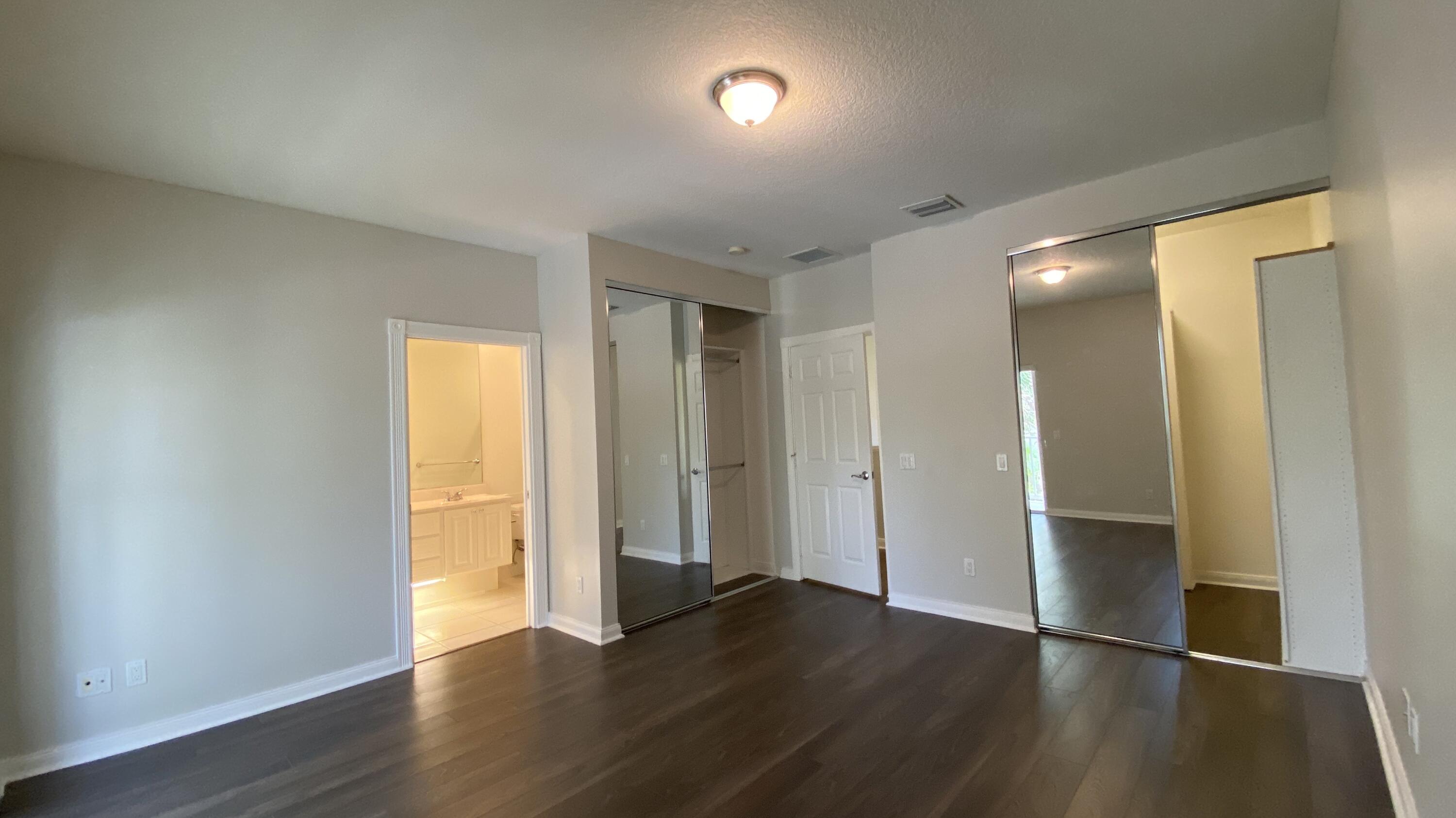 3200 West Community Drive Jupiter, FL 33458 - Photo 16 of 31 an empty room with wooden floor and windows