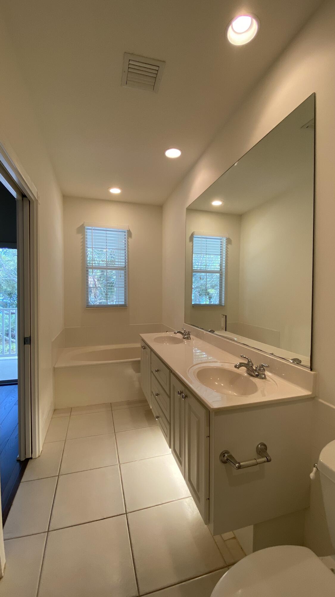 3200 West Community Drive Jupiter, FL 33458 - Photo 22 of 31 a bathroom with a granite countertop sink a toilet and mirror