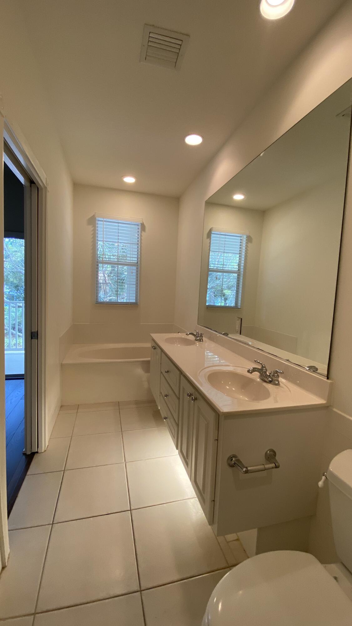 3200 West Community Drive Jupiter, FL 33458 - Photo 23 of 31 a bathroom with a sink a toilet and mirror