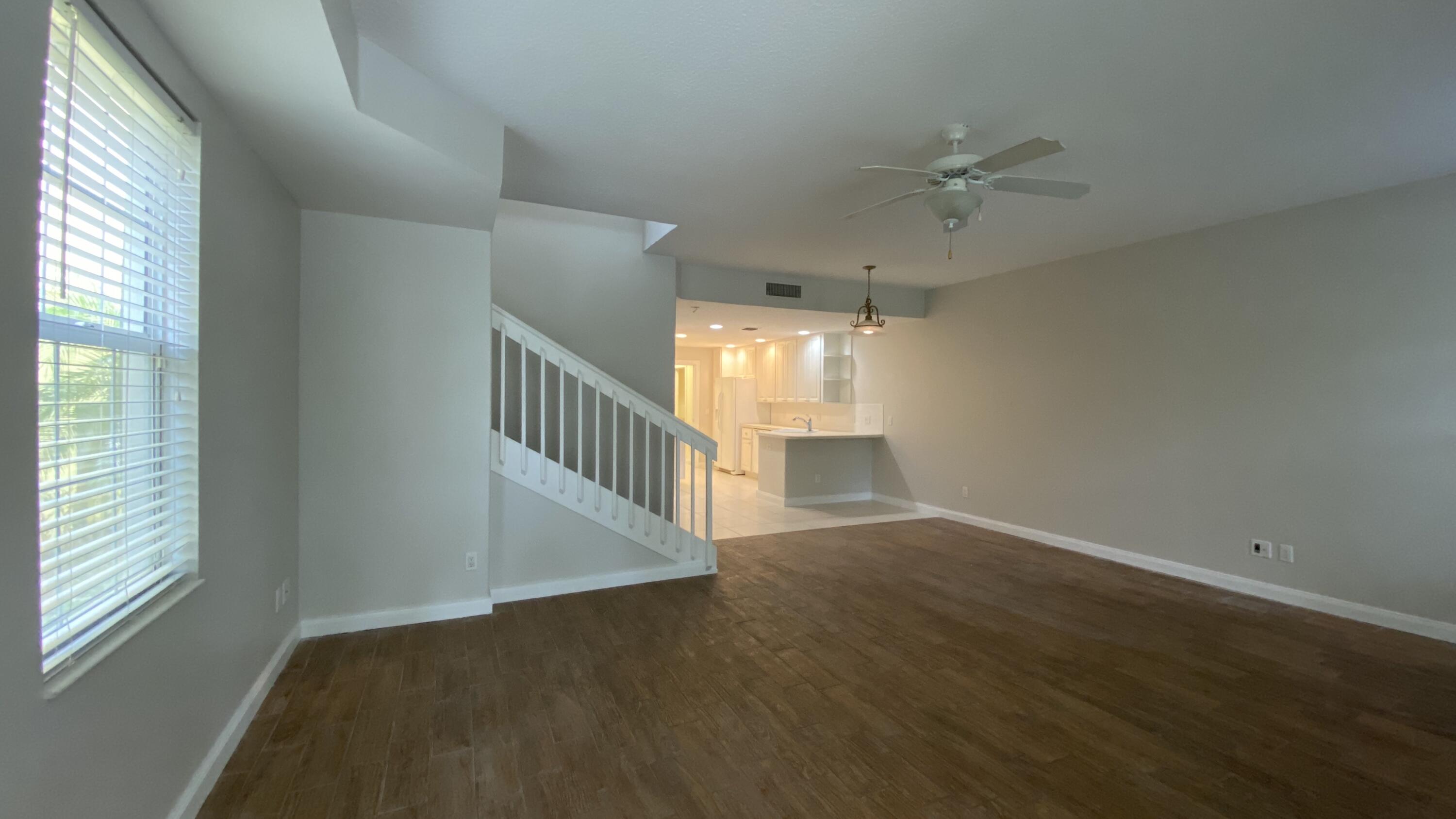 3200 West Community Drive Jupiter, FL 33458 - Photo 8 of 31 an empty room with wooden floor fan and windows