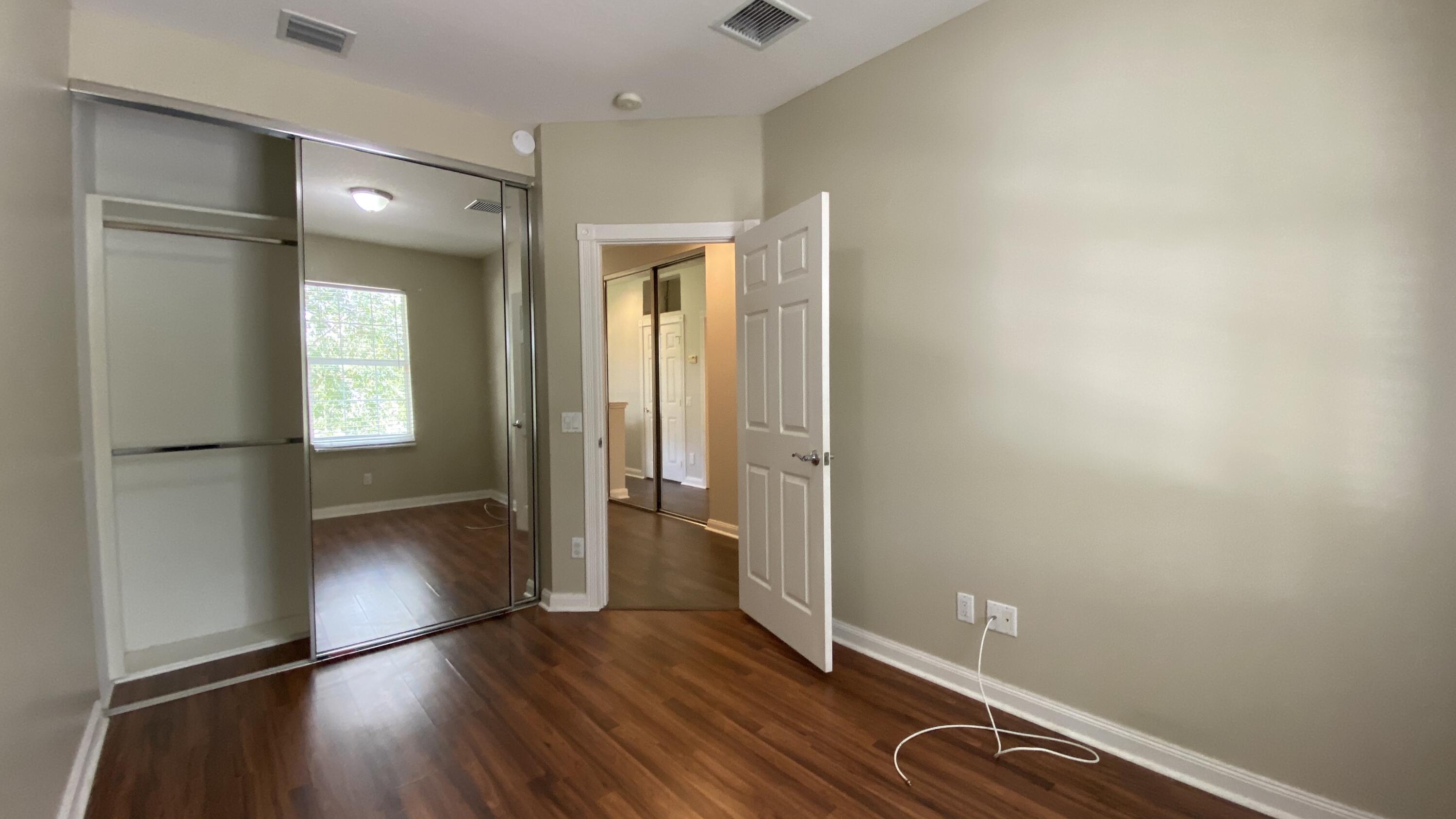 3200 West Community Drive Jupiter, FL 33458 - Photo 10 of 31 wooden floor in an empty room with a window