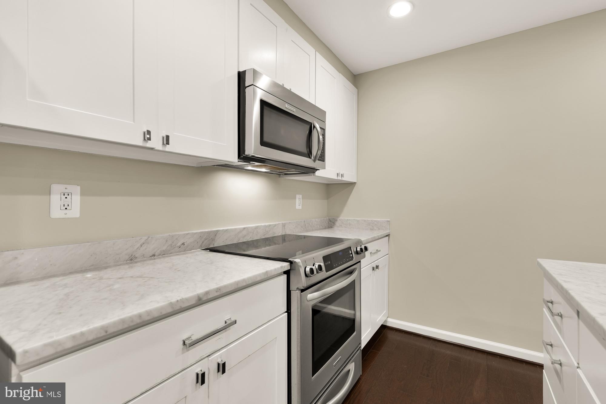 1845 Kalorama Road Northwest, Unit 1 Washington, DC 20009 - Photo 13 of 39 a kitchen with granite countertop cabinets stainless steel appliances and wooden floor