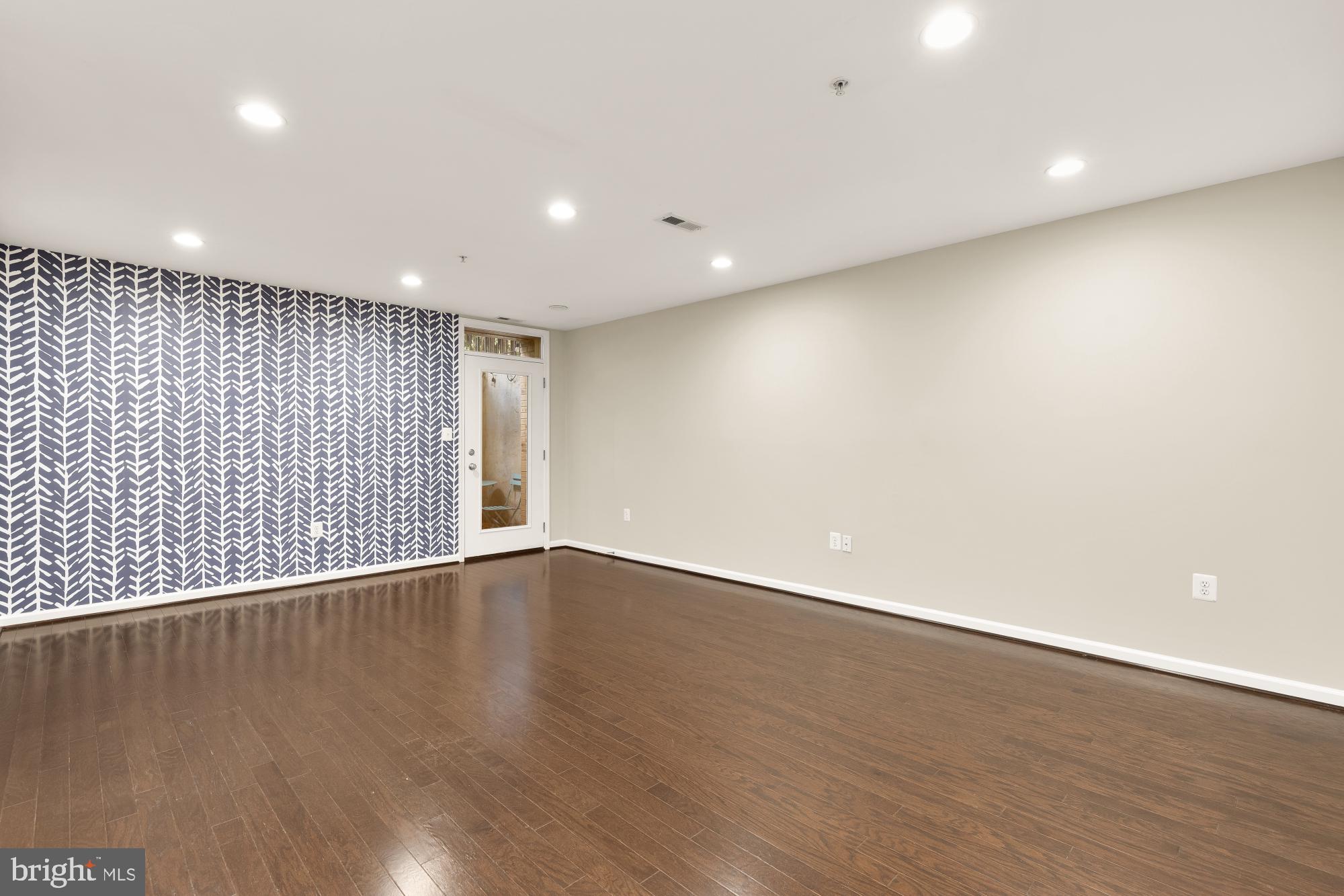 1845 Kalorama Road Northwest, Unit 1 Washington, DC 20009 - Photo 15 of 39 a view of an empty room with wooden floor and a window