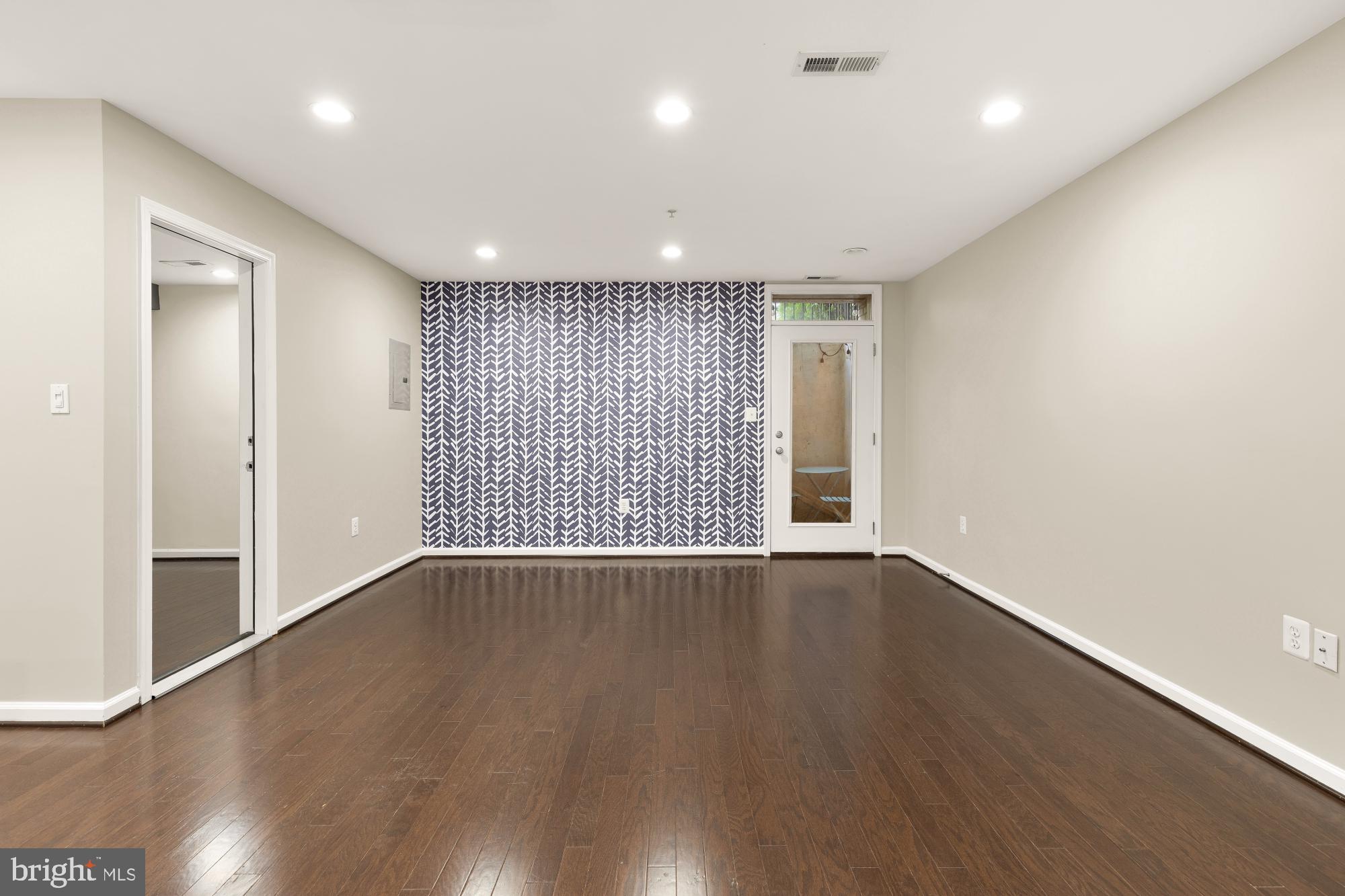 1845 Kalorama Road Northwest, Unit 1 Washington, DC 20009 - Photo 16 of 39 a view of an empty room with wooden floor and a window