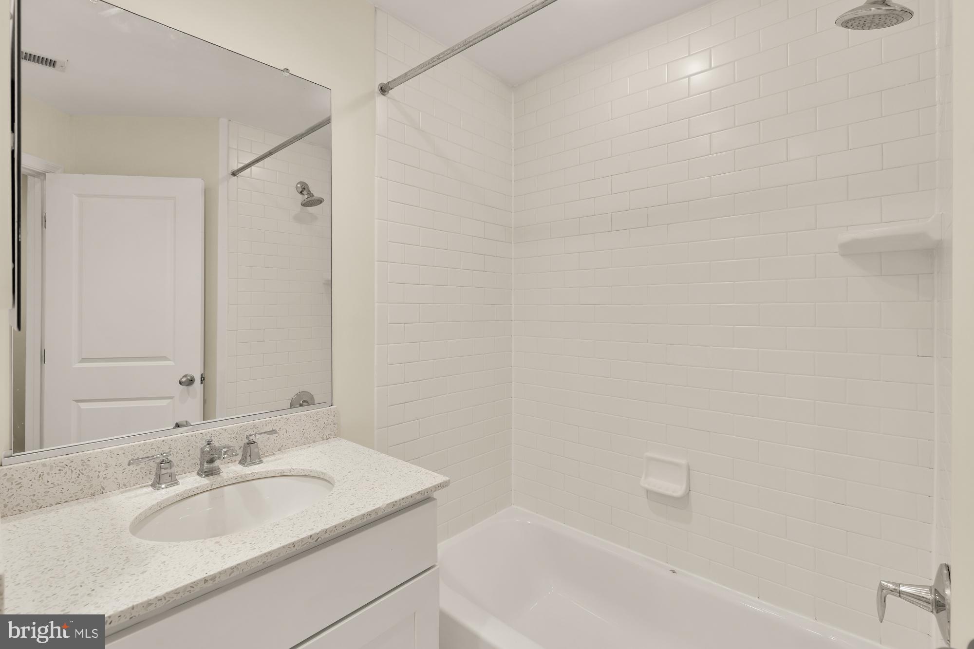 1845 Kalorama Road Northwest, Unit 1 Washington, DC 20009 - Photo 20 of 39 a bathroom with a granite countertop sink and a bathtub
