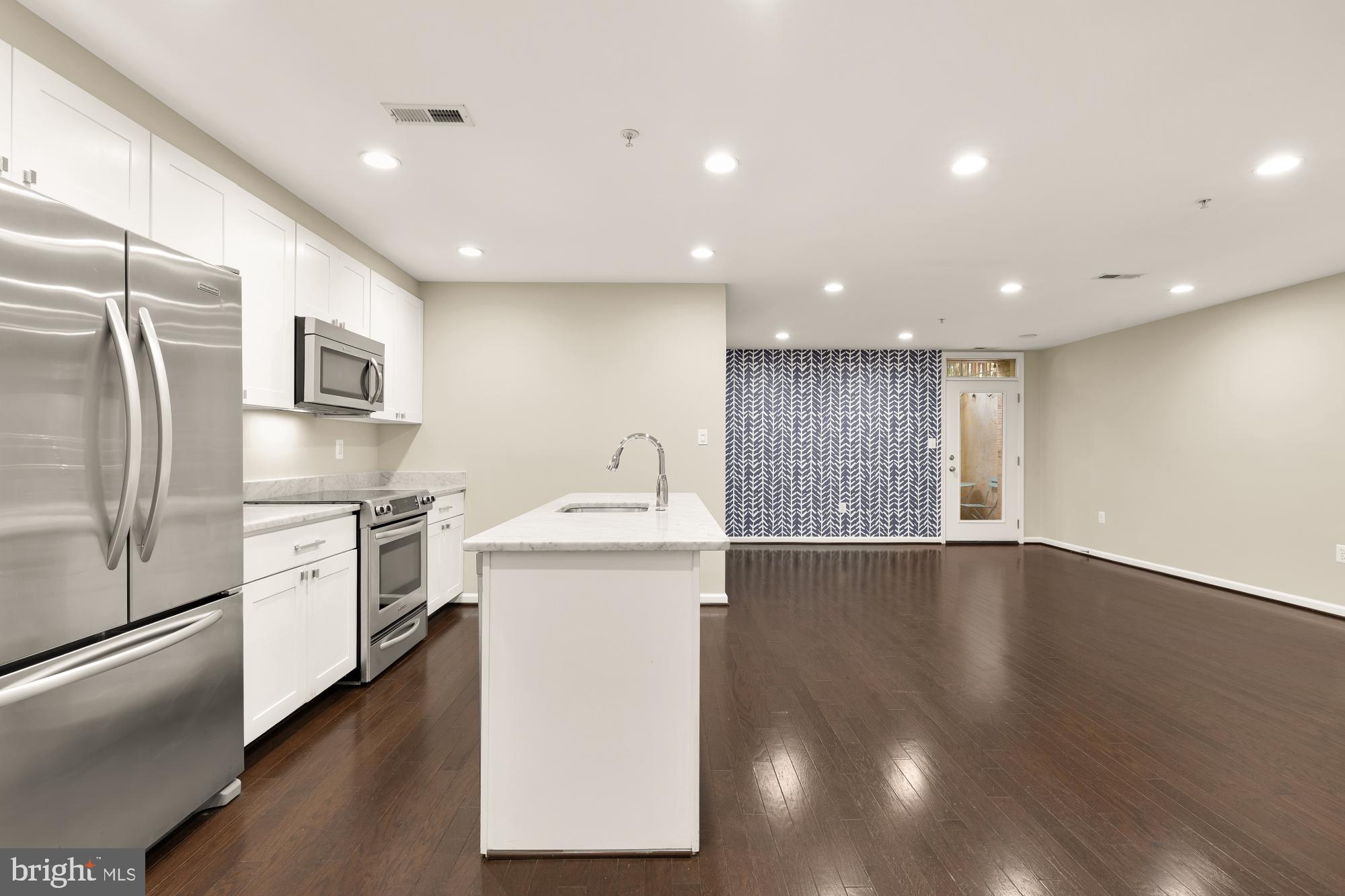 1845 Kalorama Road Northwest, Unit 1 Washington, DC 20009 - Photo 5 of 39 a kitchen with a sink stainless steel appliances and wooden floor
