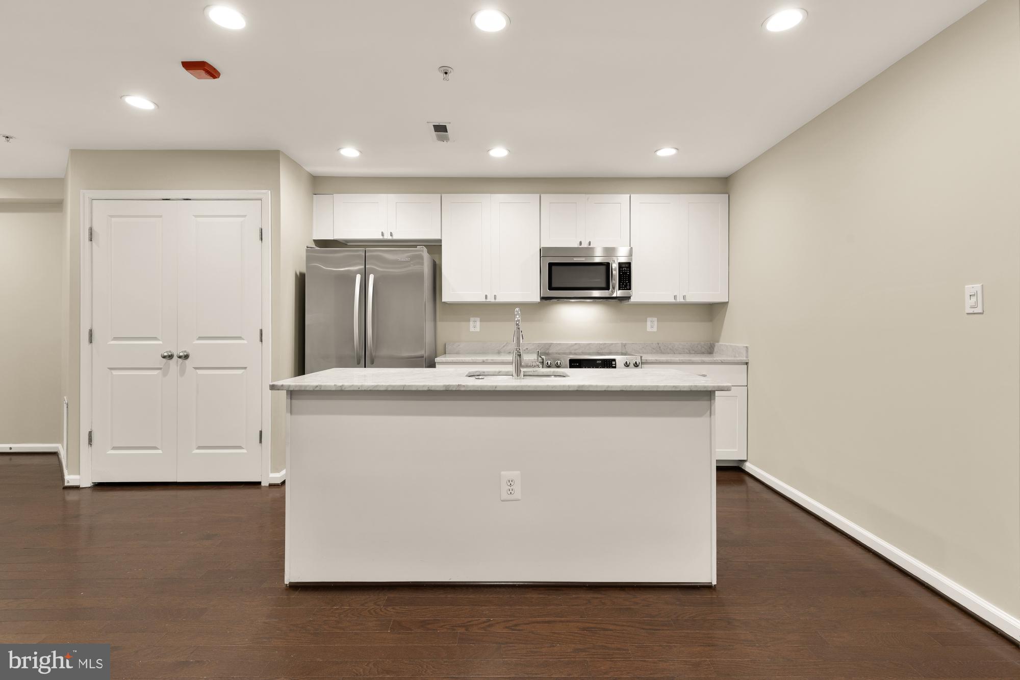 1845 Kalorama Road Northwest, Unit 1 Washington, DC 20009 - Photo 7 of 39 a kitchen with kitchen island a sink stainless steel appliances and cabinets