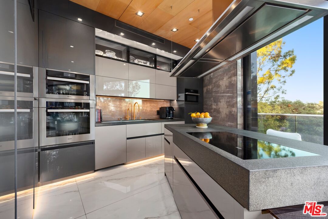 976 Bel Air Road Los Angeles, CA 90077 - Photo 5 of 23 a kitchen with stainless steel appliances kitchen island granite countertop a refrigerator and a stove