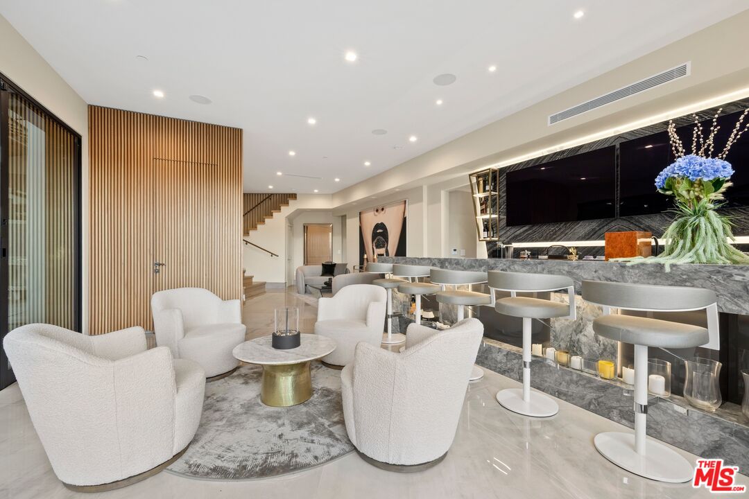 976 Bel Air Road Los Angeles, CA 90077 - Photo 7 of 23 a living room with furniture a flat screen tv and kitchen view