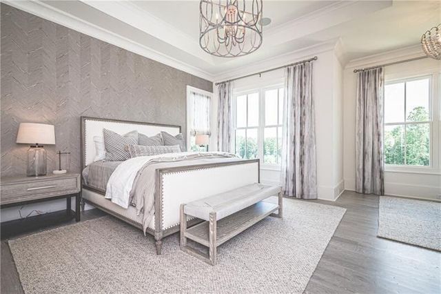 a spacious bedroom with a bed and a chandelier
