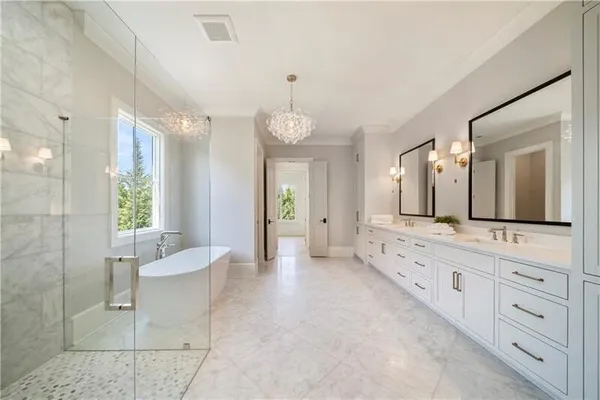 a large bathroom with a double vanity sink a large mirror and a bathtub
