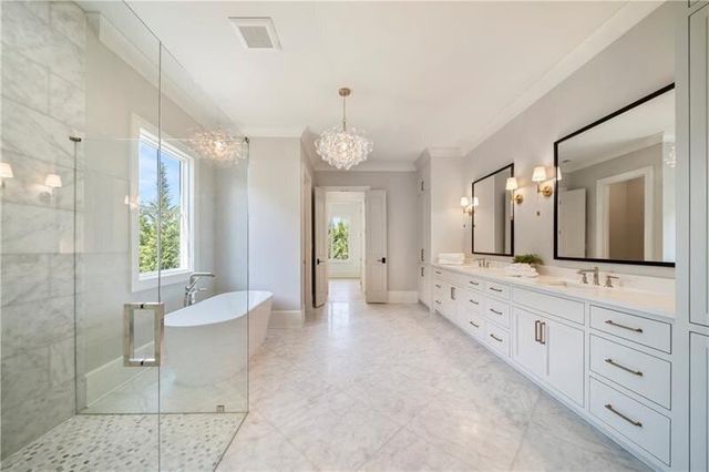 a large bathroom with a double vanity sink a large mirror and a bathtub