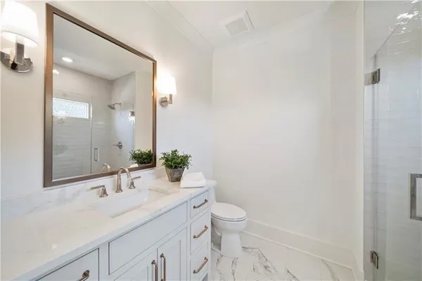 a bathroom with a sink a toilet a mirror and vanity
