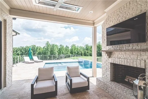 a outdoor living space with a fireplace and a flat screen tv