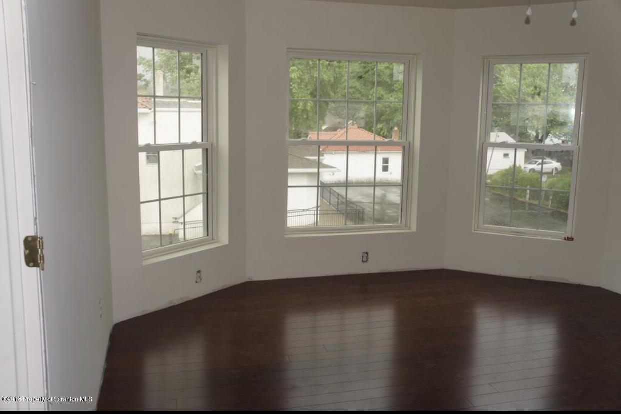2027 Green Ridge Street Dunmore, PA 18512 - Photo 2 of 6 an empty room with wooden floor and windows
